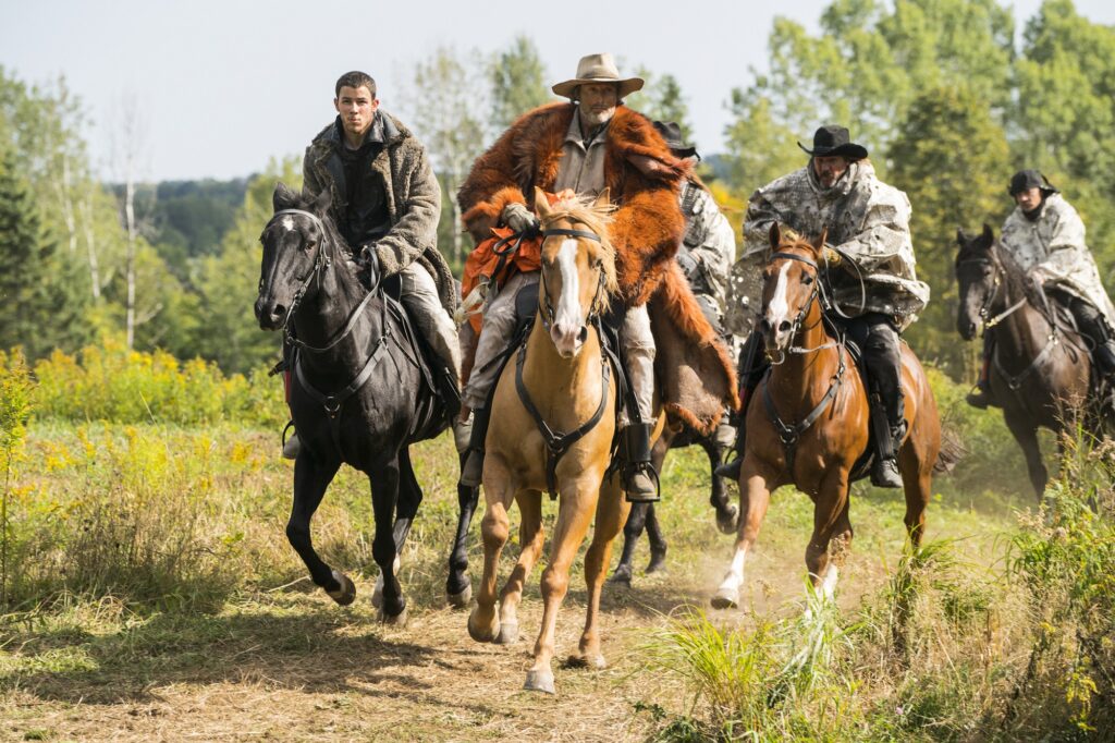 Nick Jonas and Mads Mikkelsen on horseback in Chaos Walking 2021 film
